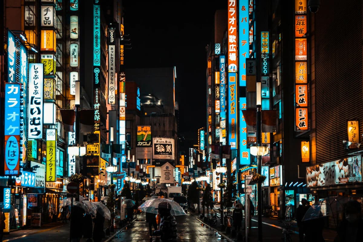 A narrow Shinjuku street lined with glowing neon signs at night in Tokyo