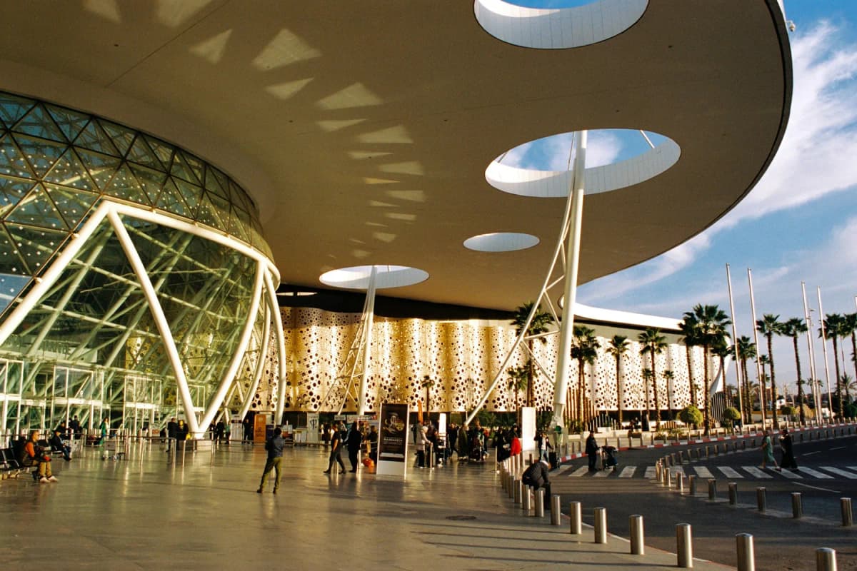 The white lattice roof and palm trees outside the terminal at Marrakech Menara Airport