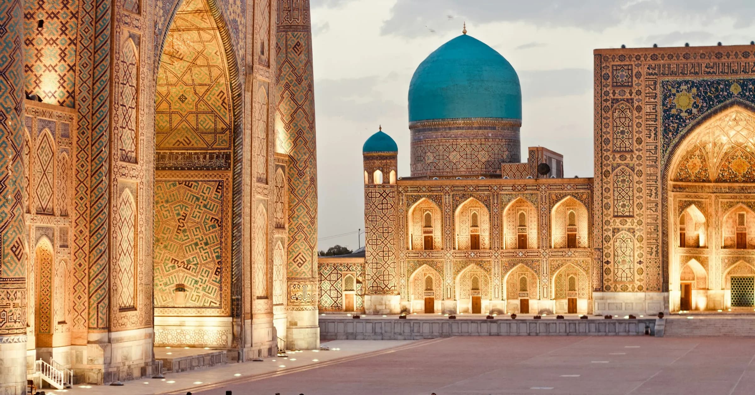 Uzbekistan itinerary: the Registan in Samarkand at dusk, with a turquoise-domed madrasa framed by tiled arches