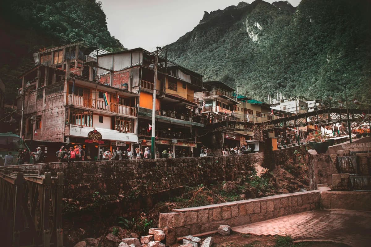Colourful buildings in Aguas Calientes below a steep green mountain
