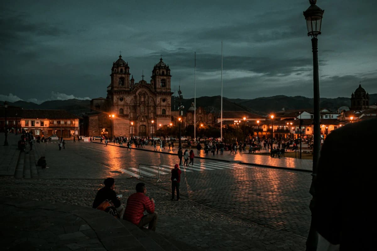 The Plaza de Armas in Cusco at night, with the lit-up church facade across the square