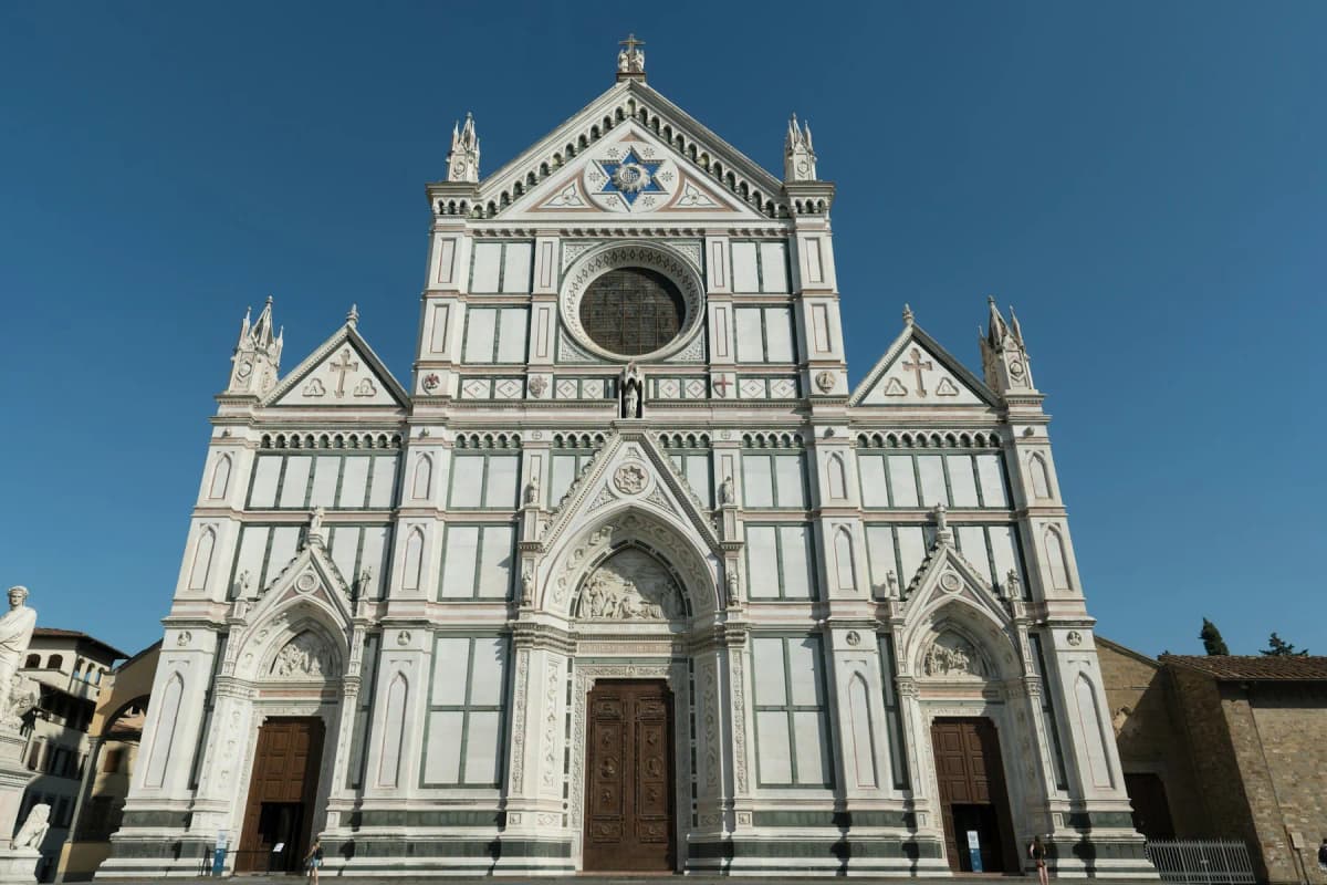 The white marble façade of the Basilica of Santa Croce in Florence against a blue sky