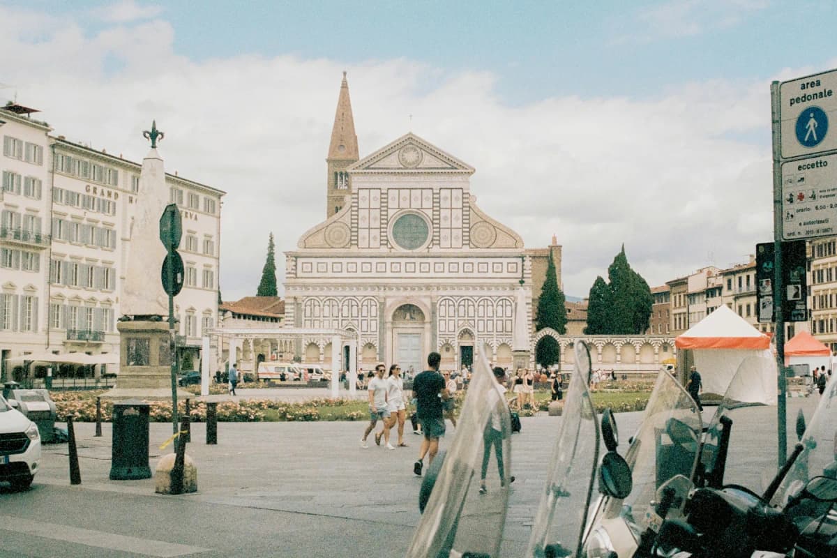 The green and white marble façade of the church of Santa Maria Novella across its piazza in Florence