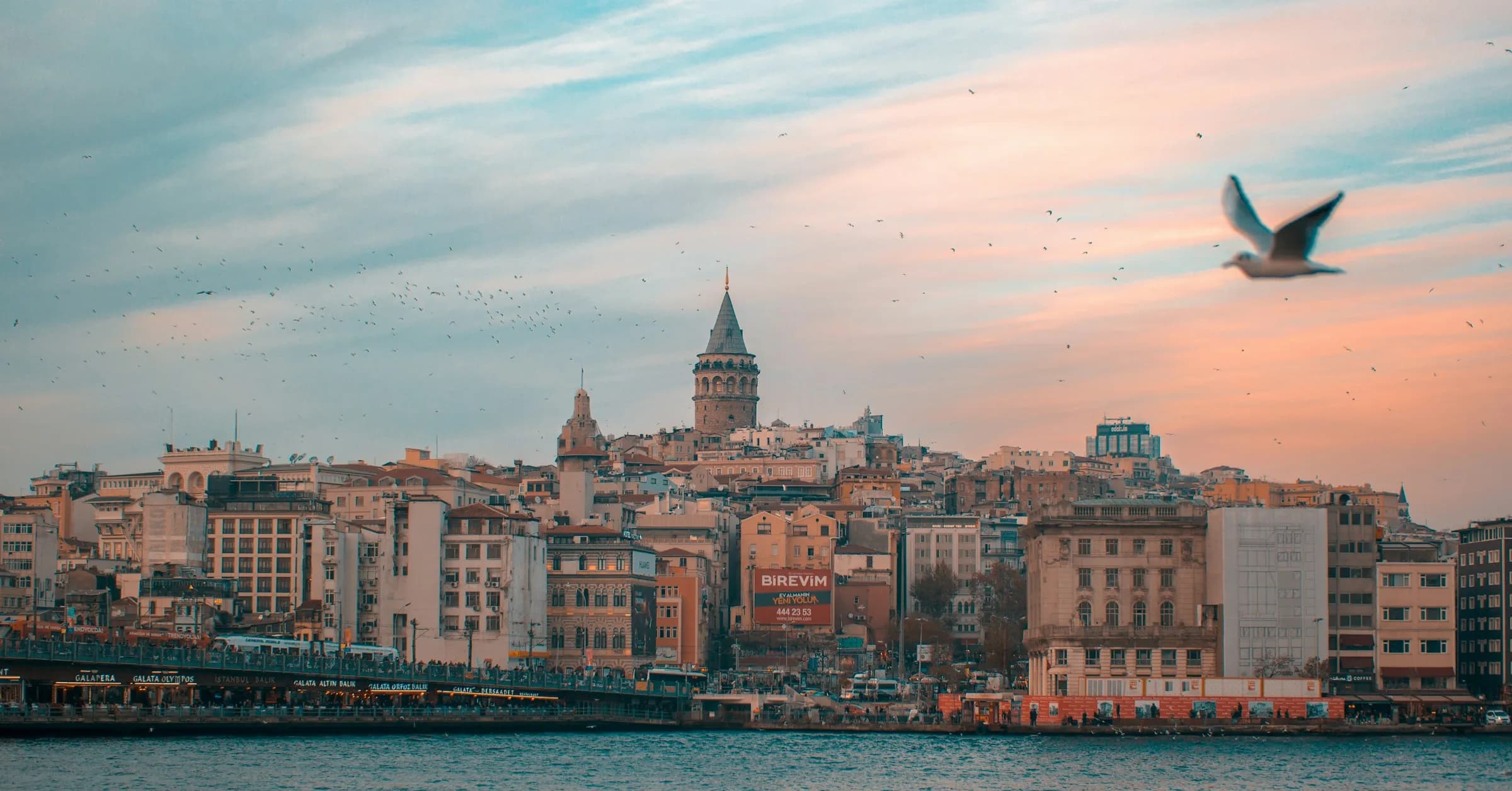 Where to stay in Istanbul: Galata Tower above the waterfront buildings of Karaköy at sunset