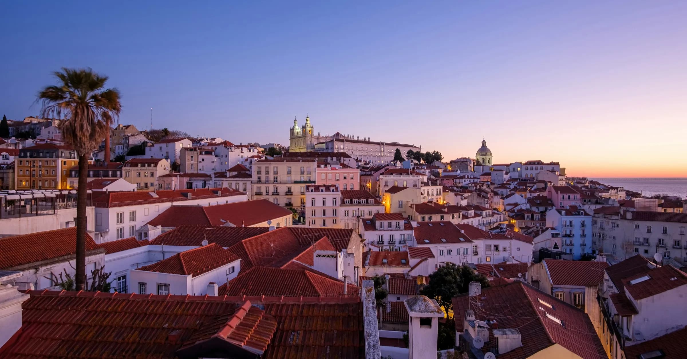 Where to stay in Lisbon: Alfama rooftops and the São Vicente de Fora monastery at sunrise