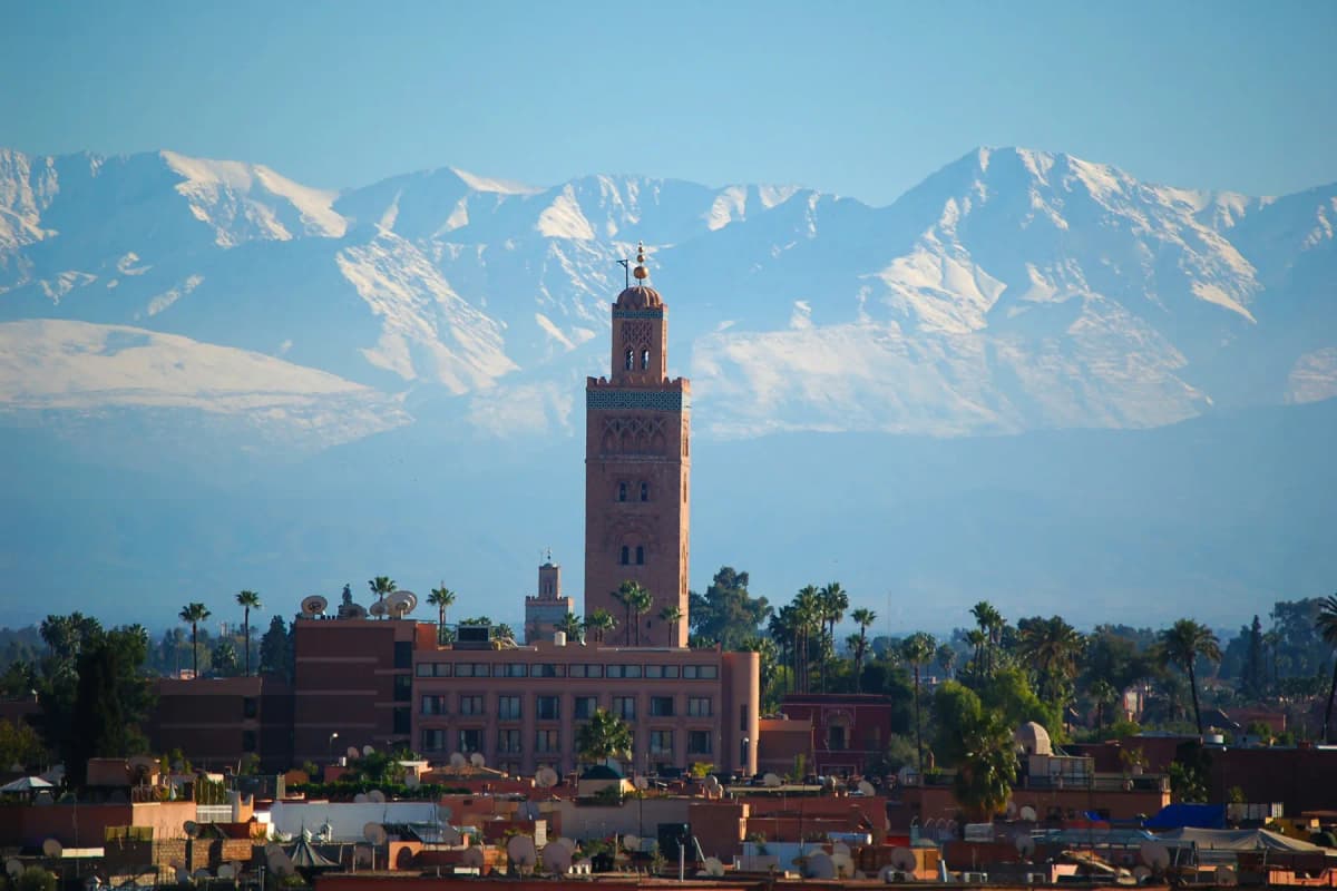 The Koutoubia minaret rising above Marrakech with the snow-capped Atlas mountains behind