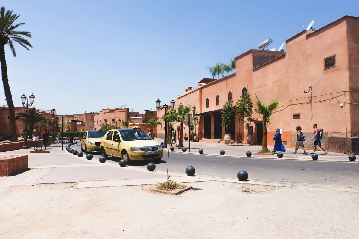 Petit taxis waiting beside the pink walls of Marrakech