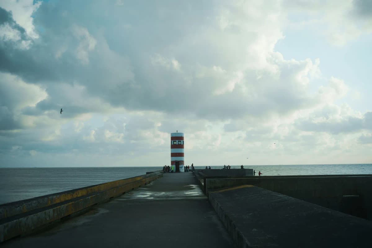 The breakwater and striped lighthouse at the mouth of the Douro, Foz do Douro, Porto