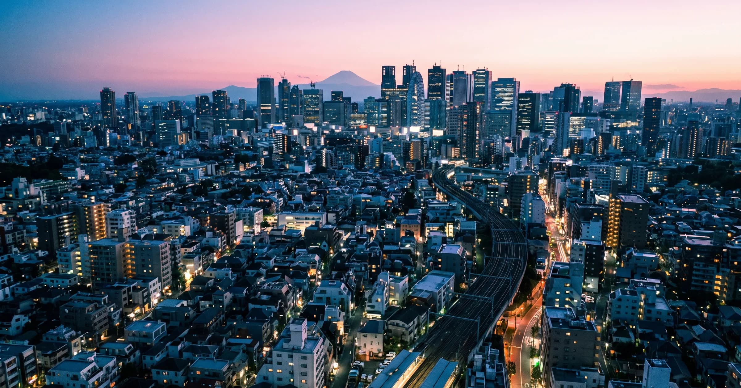 Where to stay in Tokyo: city neighbourhoods at blue hour with Mount Fuji on the horizon