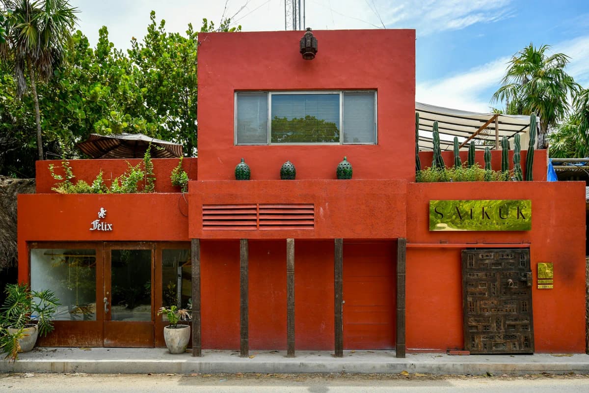 A red restaurant building on a street in Tulum town