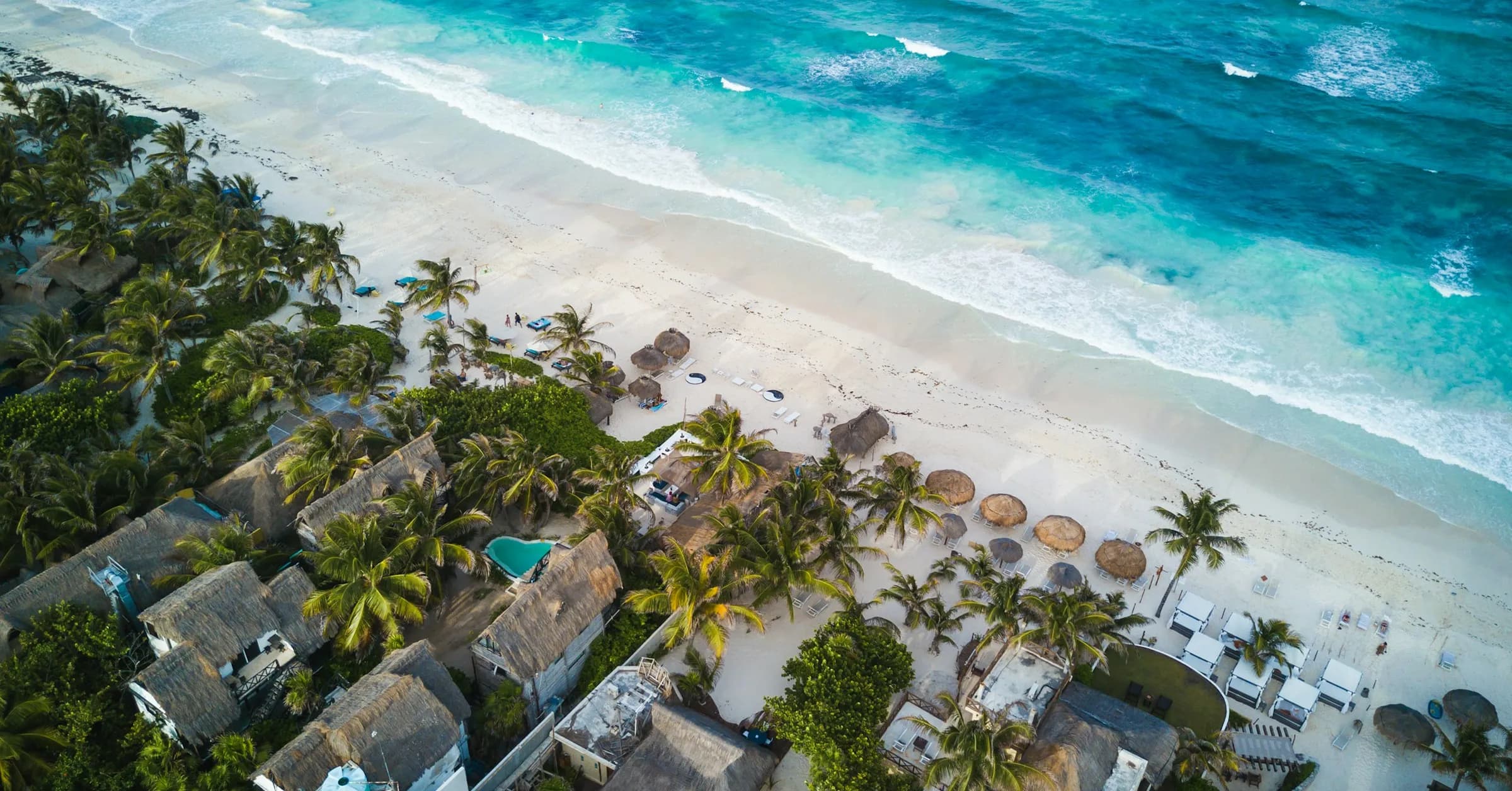 Where to stay in Tulum: beach cabanas and palms along the sand in Tulum's Hotel Zone, seen from above