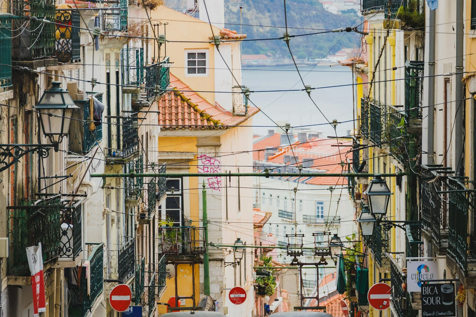 The yellow trams of the Elevador da Bica climbing a narrow street in Lisbon's old town