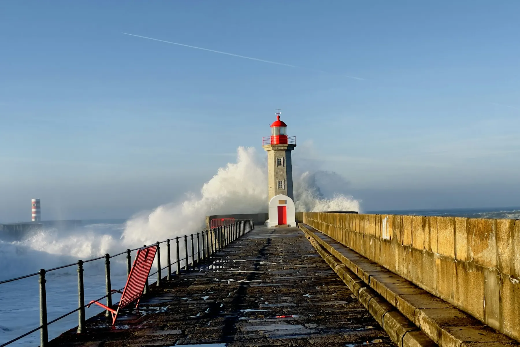 The Felgueiras lighthouse at the end of a pier at Foz do Douro, with Atlantic waves breaking