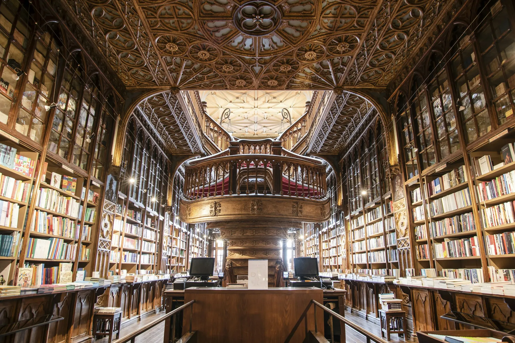The ornate carved interior and red forked staircase of Livraria Lello bookshop in Porto